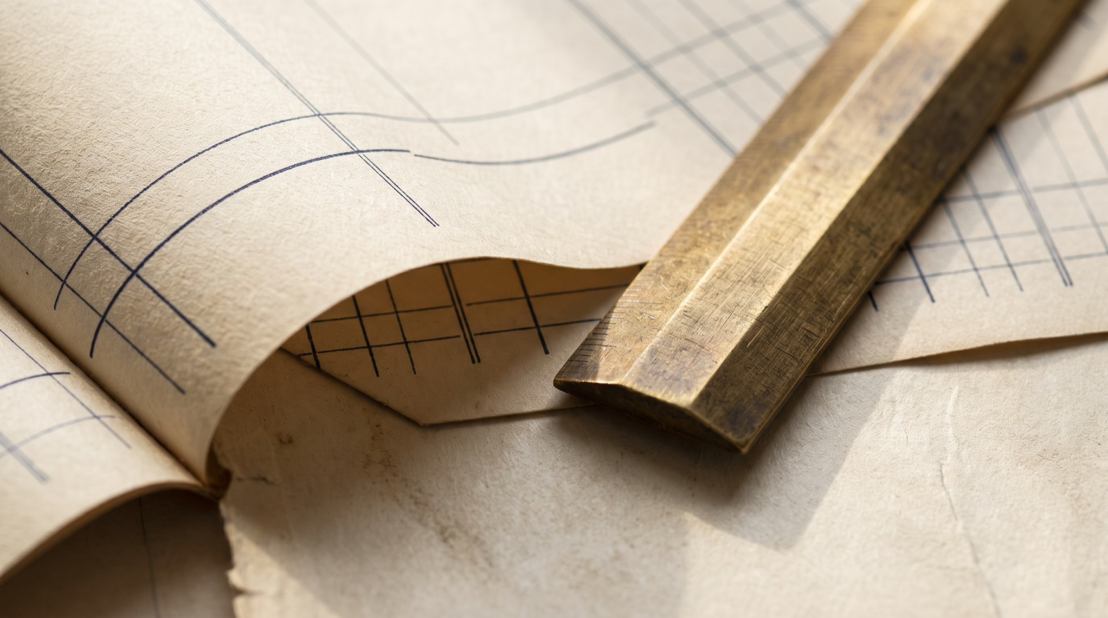 Continuous accounting ledger paper with a brass ruler laid across it